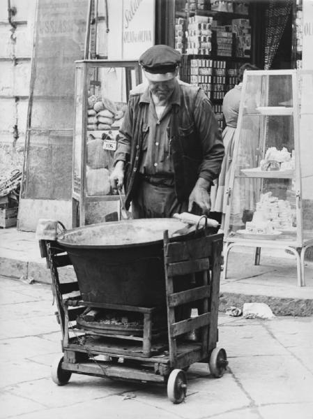 Napoli: Commercio. Napoli - Strada - Street food - Banco di un anziano venditore ambulante di pannocchie - Braciere