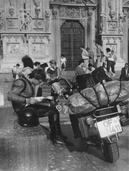 Piazza Duomo. Milano - Piazza del Duomo - Ragazzo motociclista con cartina - Casco, motocicletta