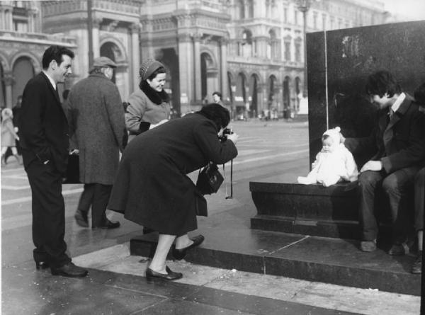 Piazza Duomo: La foto. Milano - Piazza del Duomo - Monumento a Vittorio Emanuele II - Neonata in posa davanti a una donna con macchina fotografica - Famiglia