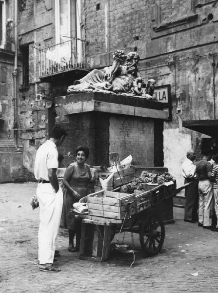 Napoli: Seconda scelta. Napoli - Vicoli - Carretto di mercato con uva - Venditore ambulante: donna con uomo - Monumento funebre