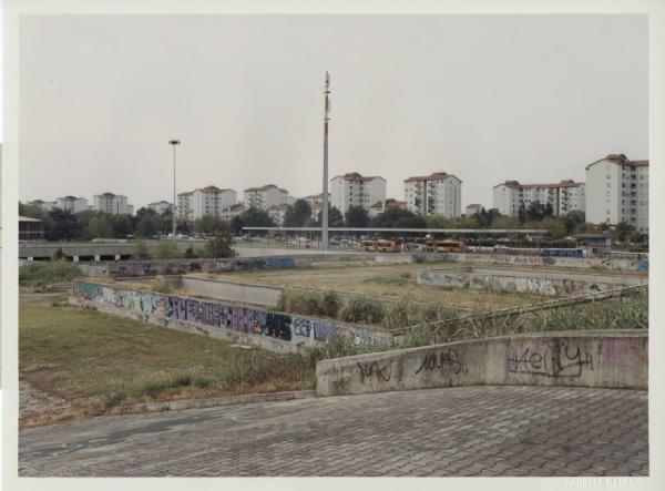 Architettura Urbana. Milano - Periferia - Fermata metropolitana e autolinee - Graffiti - Edilizia popolare sullo sfondo