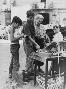 Napoli: Commercio. Napoli - Strada - Street food - Venditore ambulante di cibo: anziana - Bambini davanti al banchetto - Barattolo di latta di pomodoro