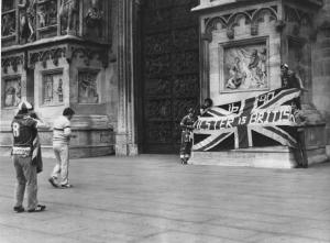 Piazza Duomo: La foto. Milano - Piazza del Duomo - Ragazzi in posa con bandiera inglese davanti a ragazzo con macchina fotografica