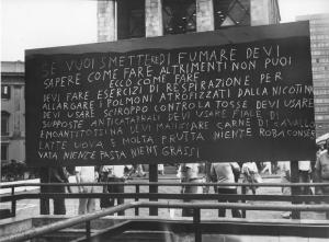 Piazza Duomo: Scritti. Milano - Piazza del Duomo - Arengario - Lavagna con scritta su come smettere di fumare