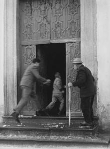 Lombardia. Portale di una chiesa - Anziano con bastone - Bambino inseguito da un uomo di corsa - Neve