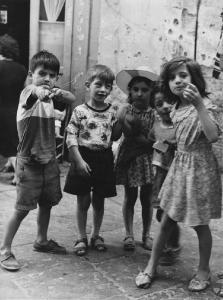 Napoli: Bimbi, scene di vita varie. Napoli - Vicoli - Ritratto di gruppo - Bambini - Arco artigianale,braccio fasciato, scarpe rotte