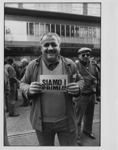Manifestazioni b/n: sciopero lavoratori 1990-1993. Milano - Regione Lombardia - Manifestazione operai metalmeccanici - Ritratto maschile - Uomo con cartello di protesta