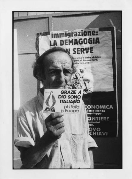Italia: manifestazione M.S.I. contro immigrazione. Milano - Manifestazione politica Movimento Sociale Italiano contro immigrazione e il centro di prima accoglienza di via Corelli - Ritratto maschile - Uomo con cartolina