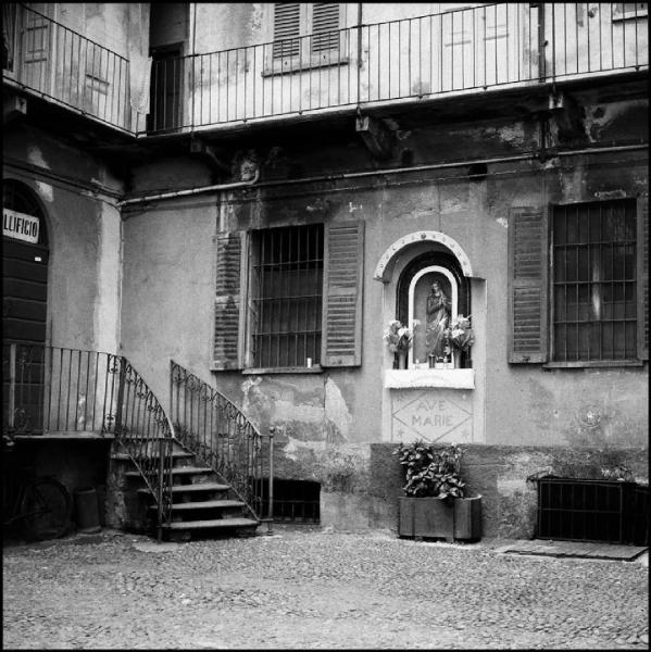 Milano - Via Vigevano 9 - Casa di ringhiera, cortile interno - Edicola con statuetta della Madonna - Scalinata con ringhiera decorata - Ballatoio