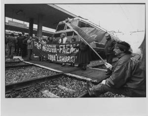 Manifestazioni Italia. Milano - Stazione ferroviaria Lambrate - Manifestazione operaia, sciopero - Gruppo di operai metalmeccanici occupano i binari - Striscione, bandiera
