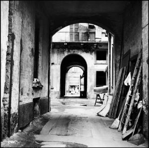 Milano - Corso Garibaldi - Casa di ringhiera: androne e cortile interno - Oggetti appoggiati alla parete: scala in legno, assi di legno, materasso, scopa