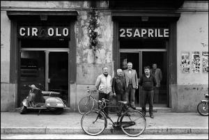 Milano - Via Comune Antico 62 - Circolo 25 Aprile, esterno - Ritratto maschile di gruppo - Biciclette parcheggiate - Motorino parcheggiato: Lambretta - Insegne pubblicitarie Motta