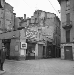 Milano - Quartiere Cinque Vie - Bar tabacchi, esterno - Strada - Palazzo danneggiato - Ritratto maschile: uomo - Insegne Coca Cola
