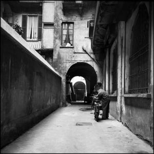 Milano - Corso di Porta Ticinese 78 - Casa di ringhiera, cortile interno - Ritratto maschile: uomo ripara una motocicletta - Androne ad arco