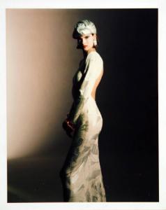 Campagna pubblicitaria per Trussardi Donna - Modella di profilo a figura intera: abito da sera bianco con ricami in argento, turbante e orecchino metallico