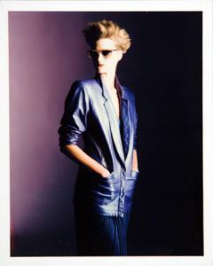 Campagna pubblicitaria per Trussardi Donna - Collezione Donna Primavera/Estate 1986 - Modella con mani in tasca: giacca di pelle e gonna plissettata