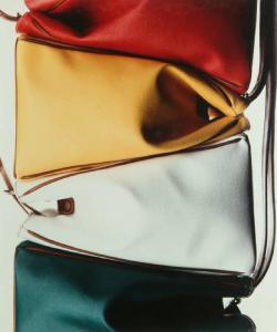 Campagna pubblicitaria per Trussardi Accessori - Pelletteria - Quattro borse in pelle impilate: rossa, gialla, bianca e verde