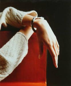 Campagna pubblicitaria per Trussardi Accessori - Mani incrociate e appoggiate su pelle rossa - Bracciale d'argento - Teste di levriero