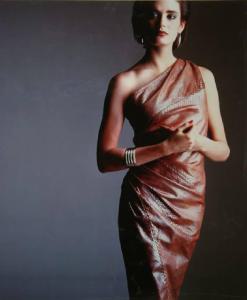 Campagna pubblicitaria per Trussardi Donna - Modella con un abito monospalla in pelle di rettile - Orecchini e largo bracciale metallici