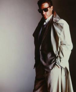 Campagna pubblicitaria per Trussardi - Modello di tre quarti: impermeabile chiaro su giacca grigia, occhiali da sole