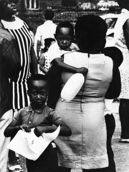 New York - Harlem - famiglia negra vista di spalle - madre con piccolo in braccio ebambino