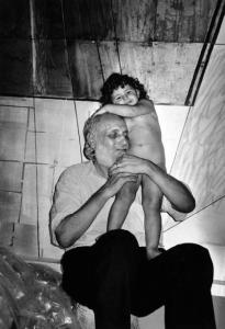 Anziano con bambina nuda in braccio