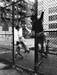 New York - Harlem - bambini giocano arrampicandosi su una recinzione