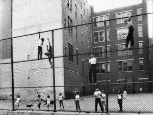 New York - Harlem - bambini giocano arrampicandosi su una recinzione