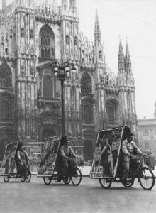 Milano. Piazza del Duomo. Locandine di film montate su tricicli
