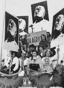 Sfilata propagandistica. Lavoratrici agricole sfilano con i ritratti del duce Benito Mussolini