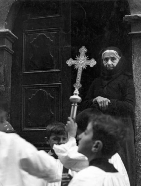 Scanno - processione - bambino con la croce - anziana donna sulla soglia
