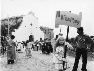 Sacra rappresentazione - bambina travestita da angelo con cartello recante la scritta "il figliuol prodigo"