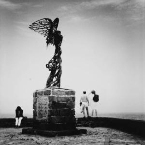Naxos. Lungomare - statua di Nike (Vittoria alata) - persone