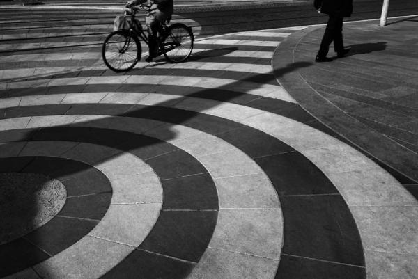 Tramsformazione. Cinisello Balsamo - Cantiere della metrotranvia - Via Frova - Pavimentazione - Binari - Persona in bicicletta e pedone (particolari delle gambe)
