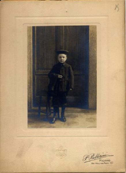 Ritratto infantile - Bambino in divisa accanto a uno sgabello / Milano - Istituto Derelitti di via Settembrini