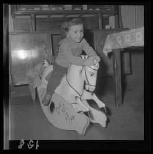 Ritratto infantile - Bambina sul cavallo a dondolo - Interno