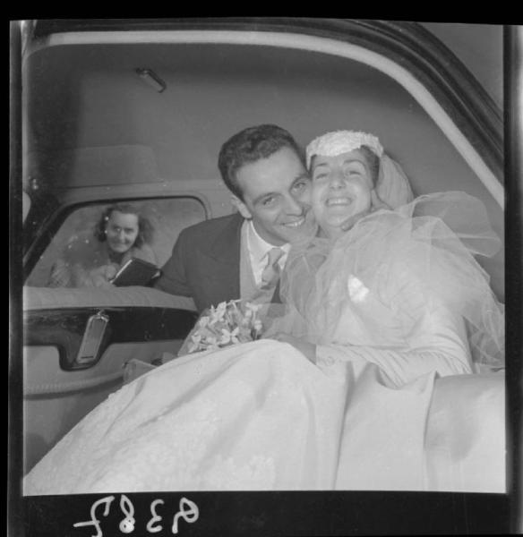 Doppio ritratto - Sposi seduti nell'abitacolo dell'autovettura - Matrimonio Sig. Zanetti - Passante in osservazione dal finestrino posteriore - Mantova