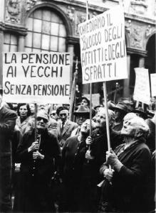 Manifestazione dei pensionati indetta dalla Camera del Lavoro - Comizio in Piazza Mercanti - Donne anziane con cartelli di protesta per il blocco degli affitti e degli sfratti