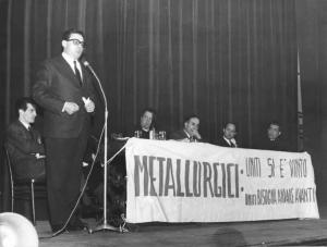 Teatro Villoresi di Monza - Interno - Assemblea unitaria dei lavoratori metalmeccanici - Palco - Tavolo della presidenza - Oratore al microfono - Striscione