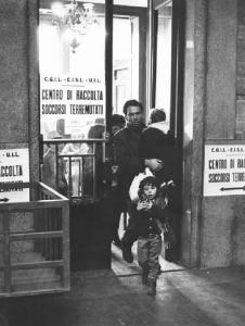 Stazione Centrale - Centro di raccolta soccorsi terremotati di Cgil, Cisl e Uil - Ingresso della stanza - Uomo con due bambini