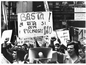 Sciopero unitario dei lavoratori metalmeccanici per la Fiat - Comizio - Lavoratori salutano con il pugno chiuso - Cartelli
