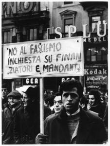 Sciopero unitario dei lavoratori dell'industria - Lavoratori in piazza del Duomo - Primo piano di lavoratore con cartello - Pubblicità sulle pareti degli edifici