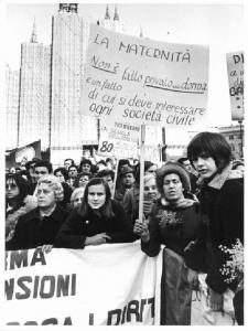 Manifestazione 8 marzo per la giornata internazionale della donna - Comizio in piazza del Duomo - Donna con cartello sulla maternità - Mimosa - Il Duomo con impalcature