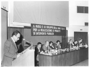 Sala - Interno - Convegno sindacale sui trasporti - Tavolo della presidenza, tra i relatori Leonardo Banfi - Oratore al microfono - Parola d'ordine