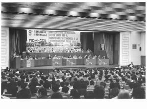 Sala dei congressi della Provincia - Interno - IX congresso provinciale della Fiom Cgil - Palco - Tavolo della presidenza con oratori - Parola d'ordine - Bandiera Flm e Fiom