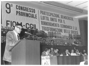 Sala dei congressi della Provincia - Interno - IX congresso provinciale Fiom Cgil - Palco - Bruno Trentin al microfono - Parola d'ordine - Bandiera