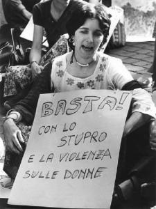 Manifestazione nazionale dei lavoratori metalmeccanici per il contratto - Ritratto femminile - Donna seduta con cartello contro violenza e stupro