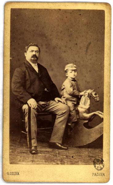 Ritrratto di famiglia - Padre seduto e figlio sul cavallo a dondolo