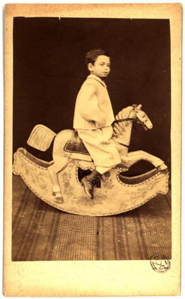 Ritratto infantile - Bambino su cavallo a dondolo