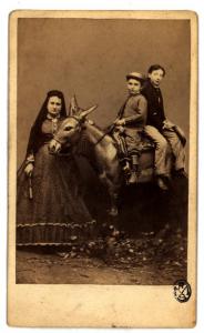 Ritratto di famiglia - Donna con velo in testa e due bambini su un asino